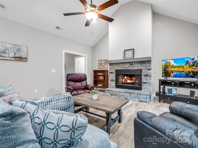 living room with high vaulted ceiling, ceiling fan, light hardwood / wood-style flooring, and a fireplace