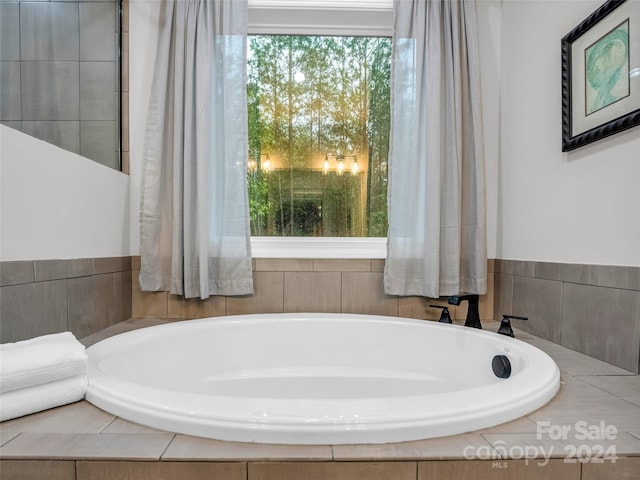 bathroom with a relaxing tiled bath