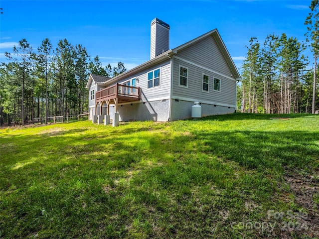 back of property with a deck and a yard