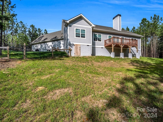 back of property with a yard and a wooden deck