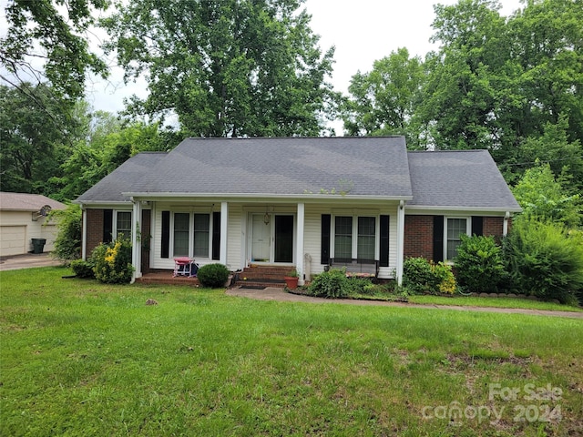 single story home featuring covered porch, a garage, and a front yard