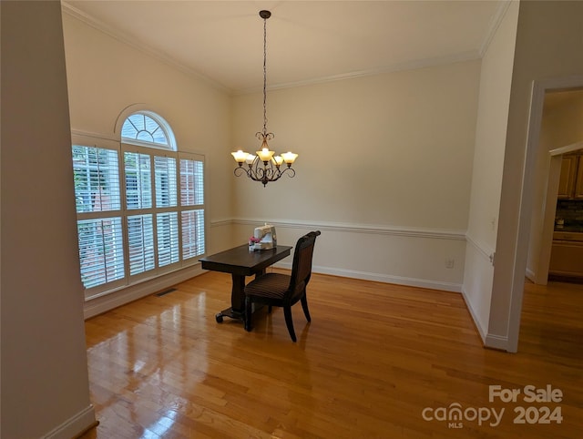 unfurnished dining area with light hardwood / wood-style flooring, crown molding, and a chandelier