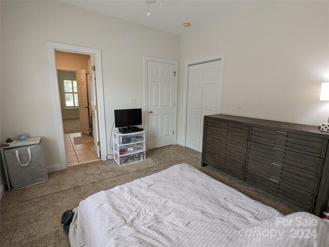 tiled bedroom featuring a closet and ensuite bath