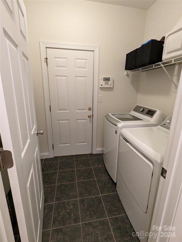 laundry room featuring washer and dryer and dark tile floors