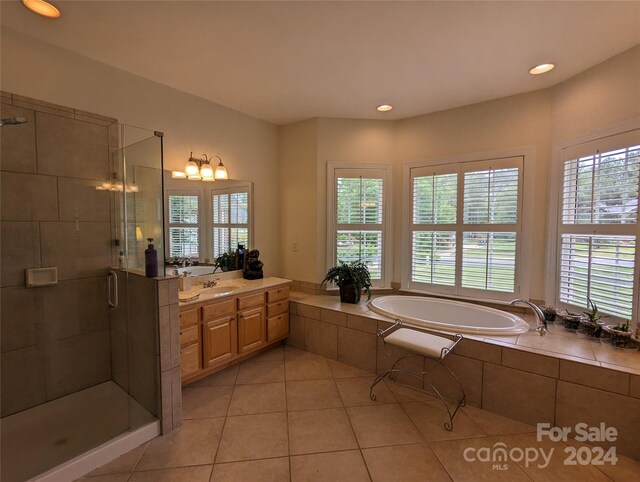 bathroom featuring separate shower and tub, oversized vanity, and tile floors