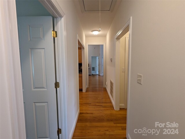 corridor with hardwood / wood-style flooring