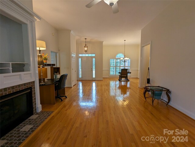 interior space featuring a fireplace, ceiling fan with notable chandelier, and hardwood / wood-style floors