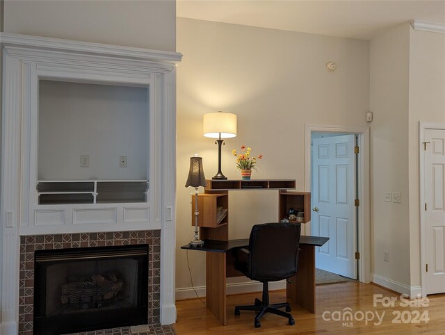 office with a fireplace and wood-type flooring