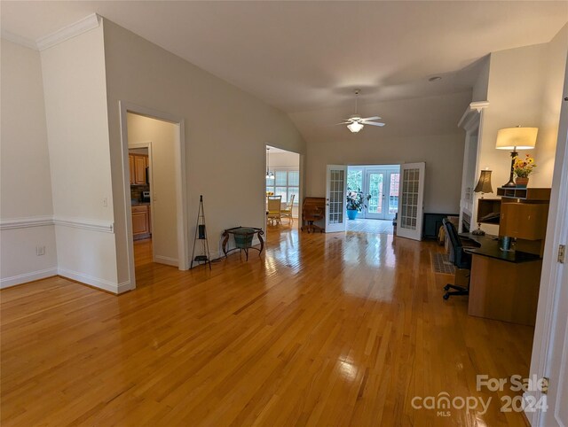 unfurnished living room with hardwood / wood-style flooring, lofted ceiling, ceiling fan, and french doors