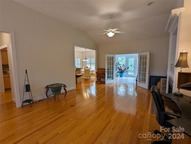 office area with french doors, lofted ceiling, a fireplace, light hardwood / wood-style flooring, and ceiling fan