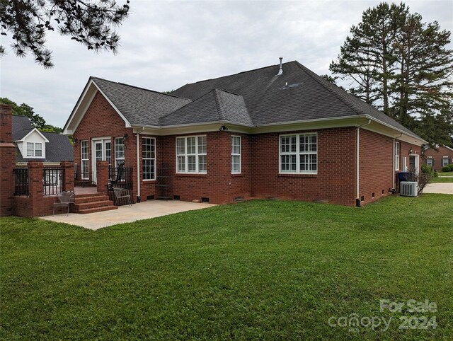 back of house with central AC and a yard