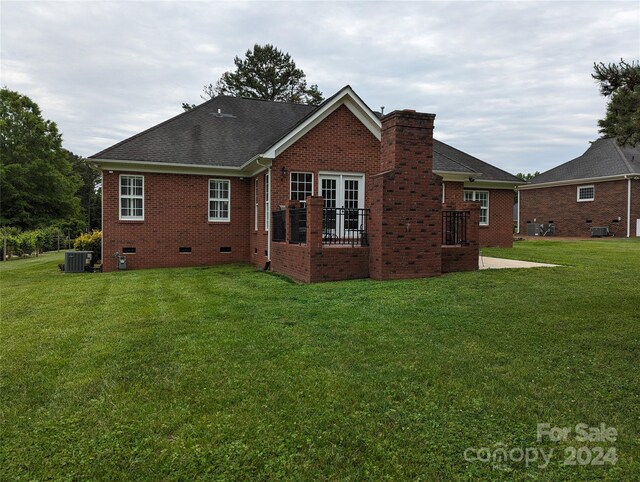 back of house featuring central AC and a yard