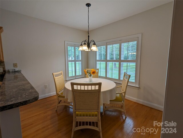 dining area featuring hardwood / wood-style flooring, plenty of natural light, and an inviting chandelier