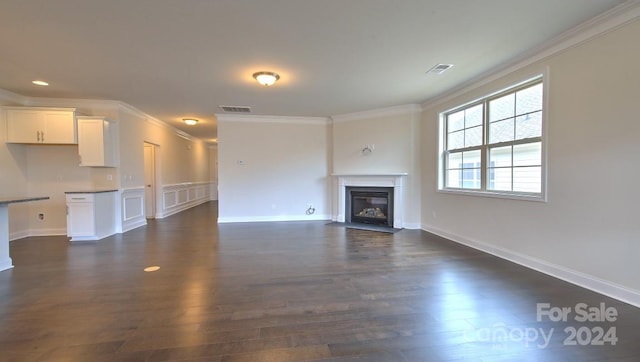 unfurnished living room featuring crown molding and dark wood-type flooring