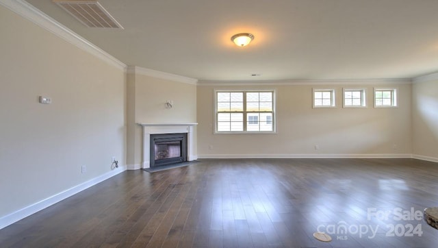 unfurnished living room featuring dark hardwood / wood-style floors and ornamental molding