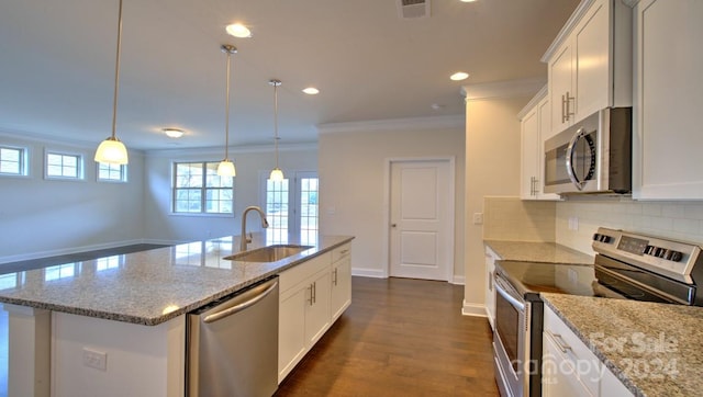 kitchen featuring stainless steel appliances, a center island with sink, tasteful backsplash, dark wood-type flooring, and sink