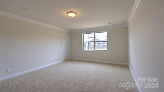 carpeted empty room featuring crown molding