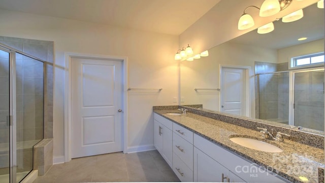 bathroom with walk in shower, dual sinks, tile floors, and large vanity