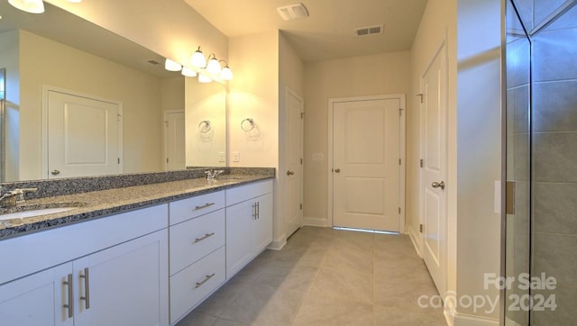 bathroom with dual bowl vanity and tile flooring