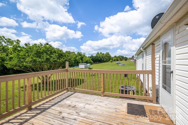 wooden terrace featuring central AC, a storage unit, and a lawn