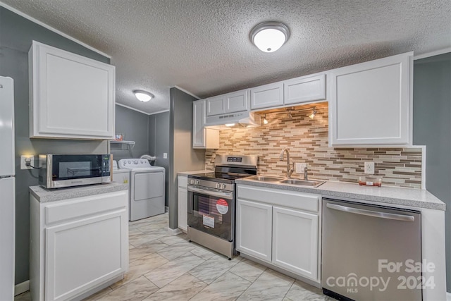 kitchen with tasteful backsplash, stainless steel appliances, sink, separate washer and dryer, and white cabinetry