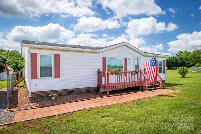 exterior space featuring a wooden deck and a front lawn