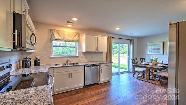 kitchen featuring backsplash, appliances with stainless steel finishes, dark hardwood / wood-style floors, and white cabinets