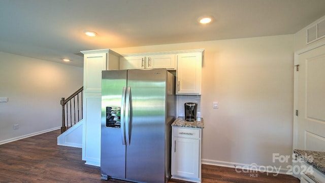 kitchen featuring white cabinetry, stainless steel fridge, dark hardwood / wood-style floors, light stone counters, and backsplash