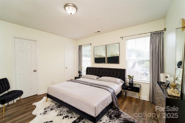 bedroom featuring dark wood-type flooring and multiple windows