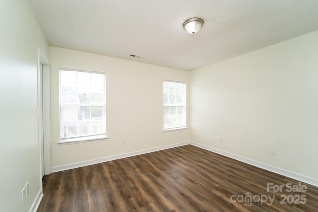 spare room with dark wood-type flooring and a textured ceiling