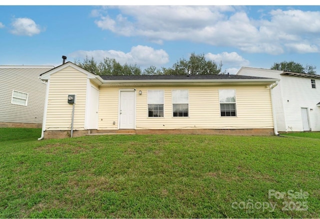 rear view of property featuring a lawn