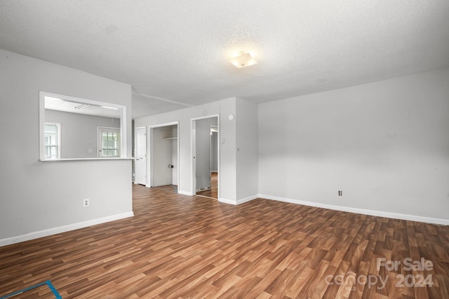 empty room with wood-type flooring and a textured ceiling