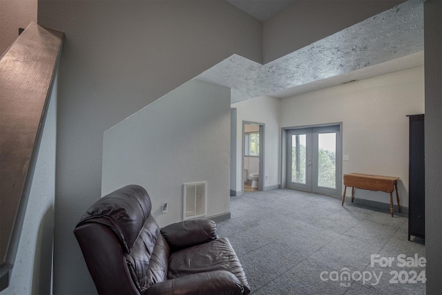 living room with a towering ceiling and french doors