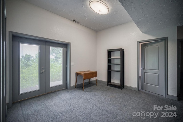 unfurnished room featuring a textured ceiling and french doors