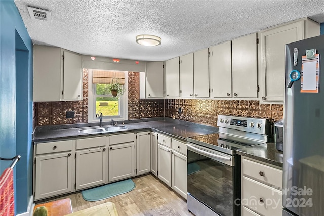 kitchen with stainless steel appliances, gray cabinets, backsplash, and sink