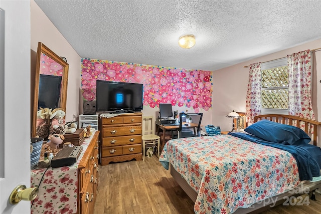 bedroom with hardwood / wood-style flooring, radiator heating unit, and a textured ceiling