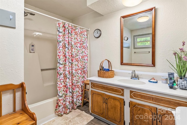 bathroom with a textured ceiling, shower / tub combo, vanity, and hardwood / wood-style floors