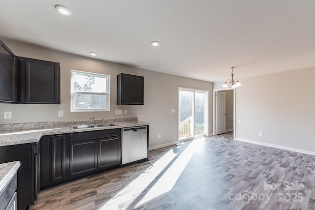 kitchen with dishwasher, sink, a wealth of natural light, and light hardwood / wood-style flooring