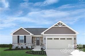 craftsman house featuring a garage and a front lawn