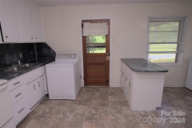 kitchen with sink, backsplash, kitchen peninsula, washer / dryer, and white cabinets