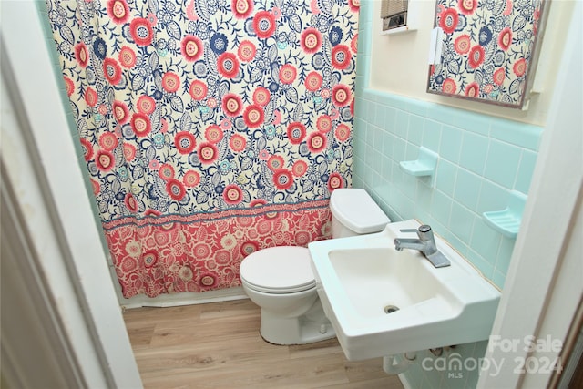 bathroom featuring sink, hardwood / wood-style floors, toilet, tile walls, and a shower with shower curtain