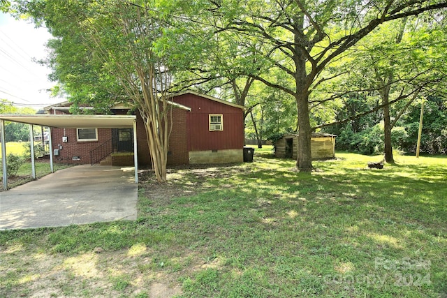 view of yard featuring a carport and a shed