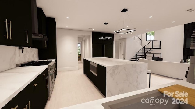 kitchen with light wood-type flooring, premium appliances, and decorative light fixtures