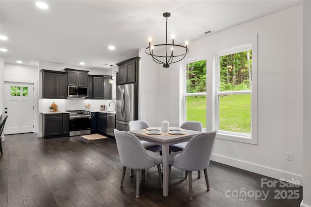 dining area with sink, dark hardwood / wood-style flooring, and a notable chandelier