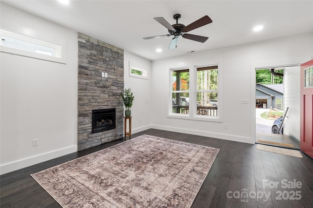 unfurnished living room featuring ceiling fan, dark hardwood / wood-style flooring, and a fireplace