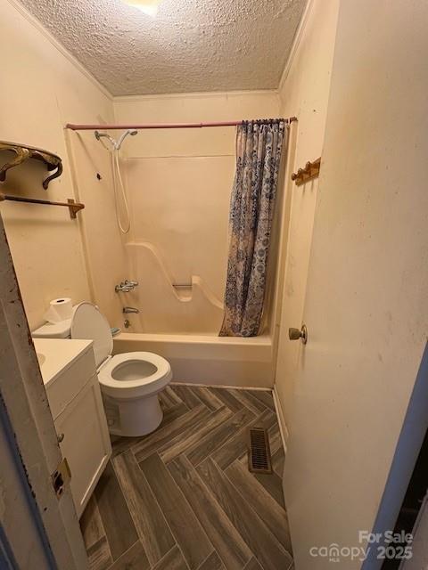 full bathroom featuring vanity, toilet, shower / bathtub combination with curtain, and a textured ceiling