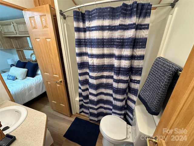 full bathroom with hardwood / wood-style flooring, vanity, toilet, and shower / bathtub combination with curtain