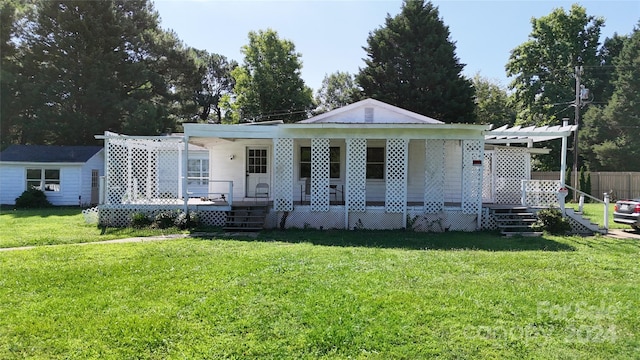 view of front of home with covered porch, a pergola, and a front yard