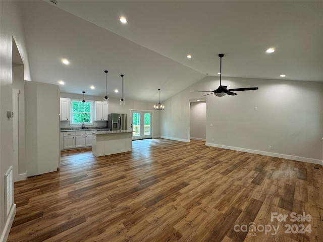 unfurnished living room with high vaulted ceiling, french doors, sink, hardwood / wood-style flooring, and ceiling fan