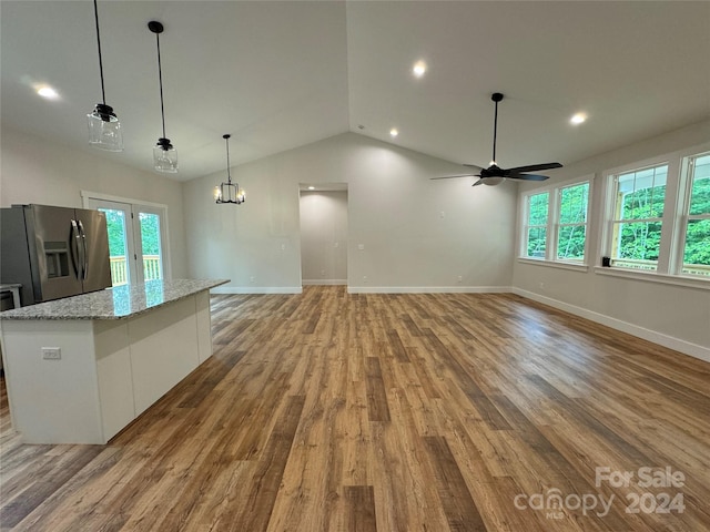 kitchen with stainless steel fridge with ice dispenser, light stone counters, decorative light fixtures, white cabinets, and ceiling fan with notable chandelier